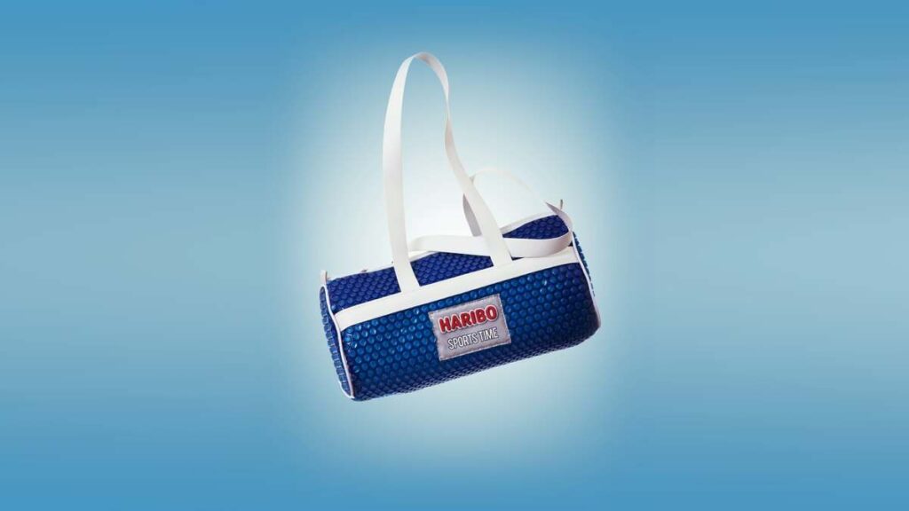 Bolsa em plástico bolha colorido azul da Booolhas, press kit do lançamento Haribo Sports Time, com a marca aplicada por patch